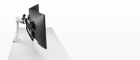 White dual Flo X monitor arm set up with 32'' screens, viewed from the side.