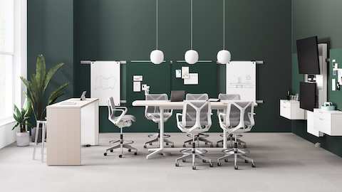 An office setting featuring a Headway communal table and a Headway conference table with a Y Base with Cosm stools, a Logic Reach providing power, and Exclave collaborative furniture.