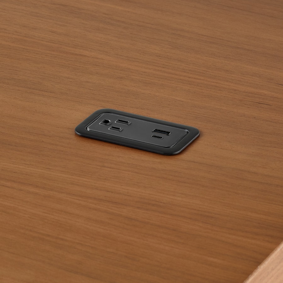 A close up of a Logic Mini with USB-C port, USB-A port, and A/C power outlet installed in the Headway communal table.