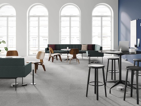 An open plan office with Tuxedo Sofas, Eames Molded Plywood Chairs, and Eames Tables all connected to power and data by Logic Reach Under-Carpet Tracks and Logic Micro Towers.