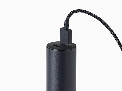 A close-up view of a black Logic Micro Tower with a cord plugged into the USB-A port.