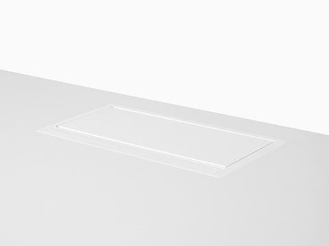 A pop-up Logic power port in the closed position, its lid flush with the work surface.