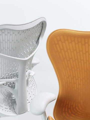 Close up of 2 Mirra 2 chairs with a Butterfly back. One in alpine and the other in ochre.