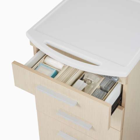 A close-up view of an open drawer with medical supplies in a Mora casework cart.
