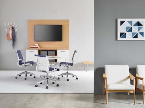 Three blue Setu Chairs face a monitor mounted on Mora System clinical casework. 