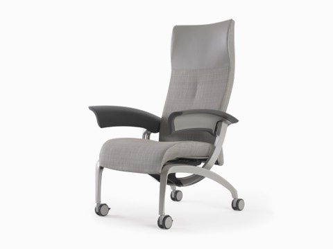 A Nala Patient Chair and ottoman in orange-patterned upholstery, viewed from a 45-degree angle.