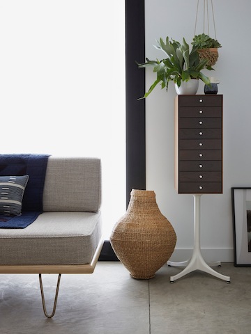 A residential setting featuring a vertical nine-drawer Nelson Miniature Chest and a Nelson Daybed. 