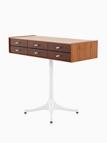 Angled view of a horizontal six-drawer Nelson Miniature Chest with a medium finish and white pedestal base. 