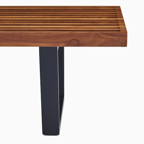 A close up detail of the ebonized wood base of the Nelson Platform Bench.