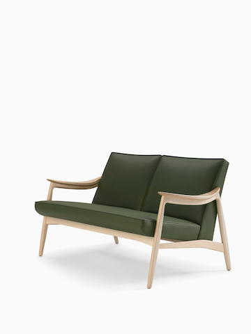 A three-quarter view of an Aspen lounge settee in green textile with maple base and arms.