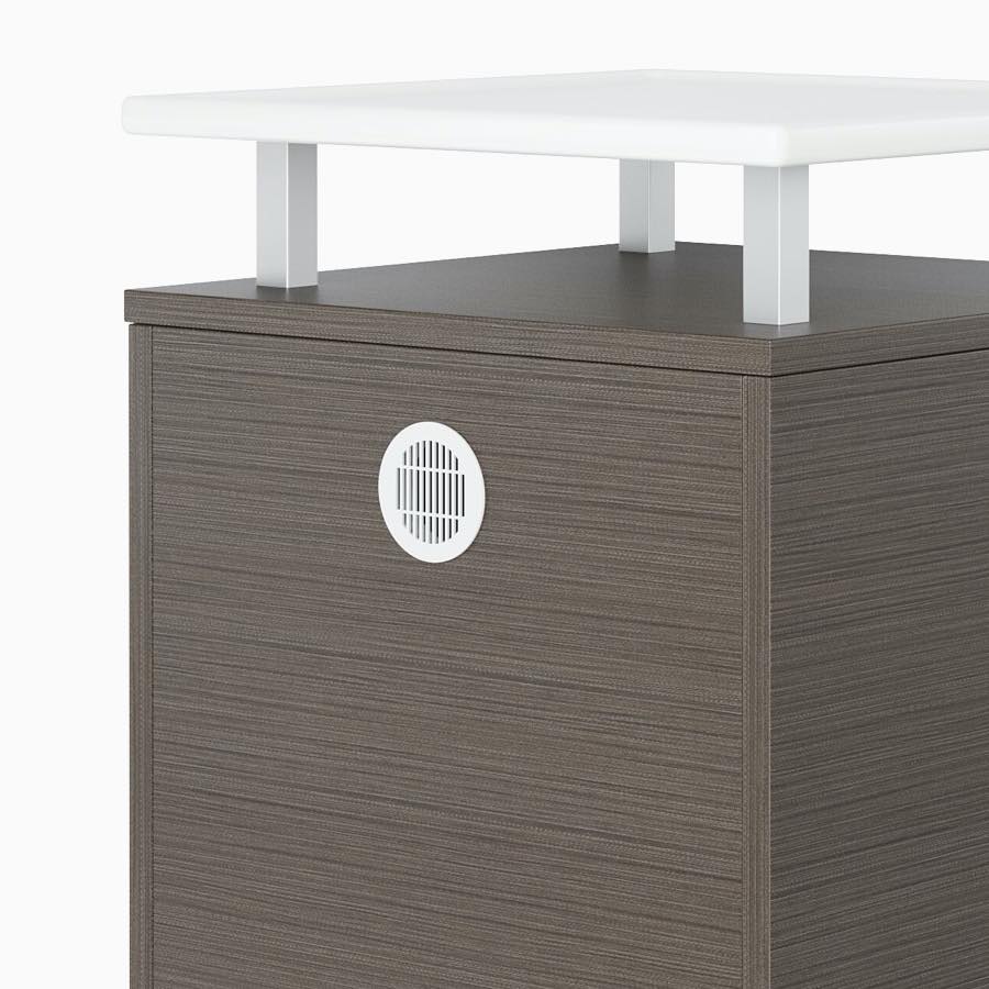 The back side of a Nemschoff Bedside Cabinet in a twill graphite finish with a vent, and a raised top in white Corian.
