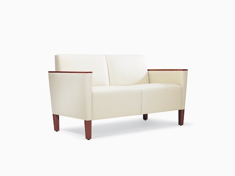 A three-quarter view of a Brava Classic Lounge Settee with white textile and wood arm caps.