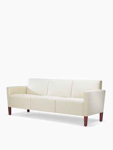 A three-quarter view of a Brava Classic Lounge Sofa with white textile and upholstered arm caps.