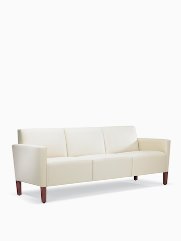 A three-quarter view of a Brava Classic Lounge Sofa with white textile and upholstered arm caps.