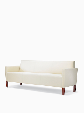 A three-quarter view of a Brava Classic Lounge Sofa with white textile and upholstered arm caps.