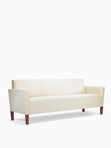 A three-quarter view of a Brava Classic Lounge Sofa with white textile and upholstered arm caps.