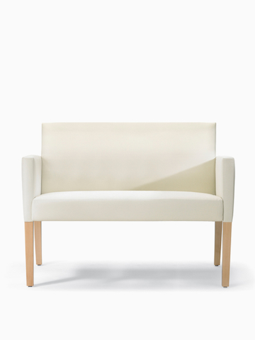 A front view of Brava 862 plus chair in white textile with upholstered arms and maple legs.