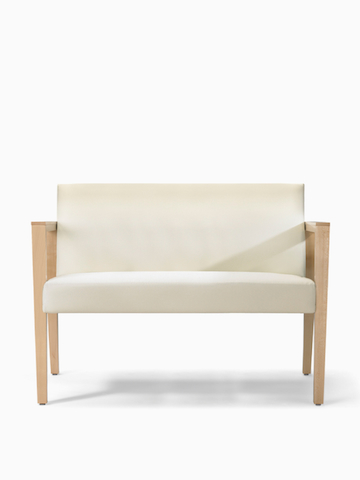 A front view of Brava 863 plus chair in white textile with open maple wood arms.
