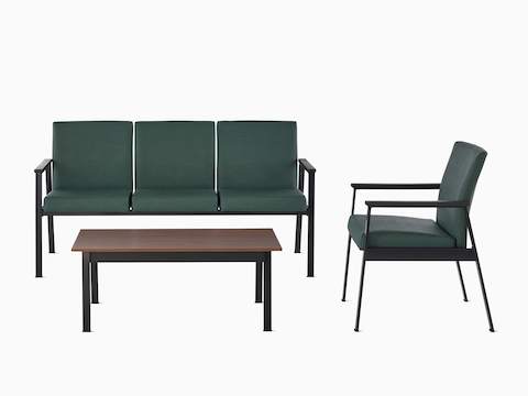 Easton three-seat multiple seating sits perpendicular to an Easton Side Chair both with green upholstery and black frame. An Easton Coffee Table with a medium matte walnut laminate top and black frame lies in front.