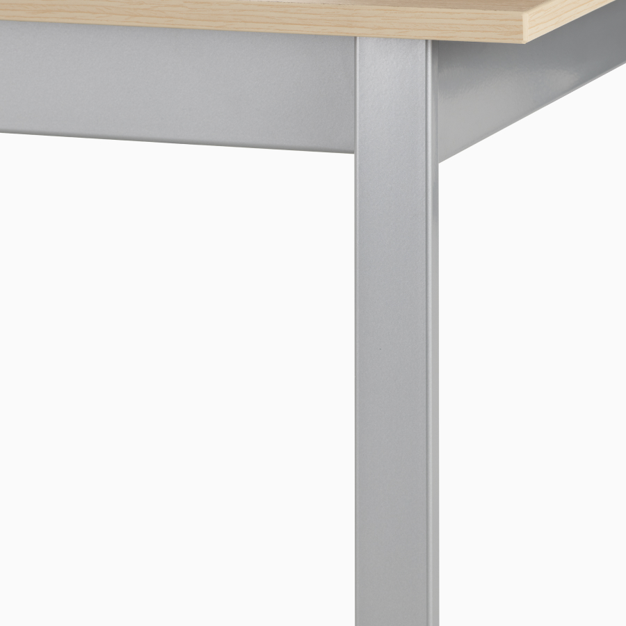 Detail view of the leg and frame of an Easton table with a silver finish.