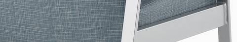 Detail of an Easton chair with blue upholstery and metallic silver four-leg base.