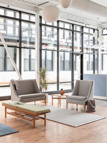 A window filled waiting area featuring a Nemschoff Iris Settee and Lounge Chair, and a Nemschoff Tamarack Table and Bench.