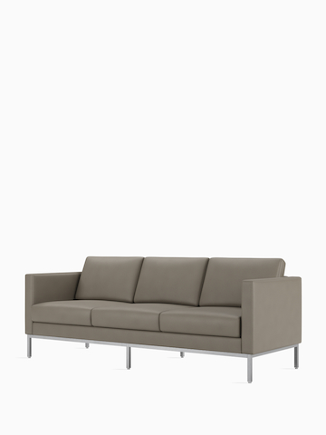A Riva 3-seat sofa in a gray textile, viewed at an angle. Select to view the Riva Sofa product page.