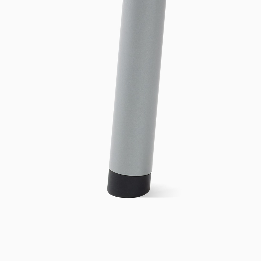 A detail of a Valor Side Chair leg in a silver finish with a standard glide in black.