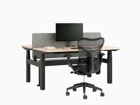 Nevi Link Sit-Stand back-to-back two-desk configuration in black with light-colored wood work surfaces and a fabric screen, monitor, and Mirra 2 Chair.