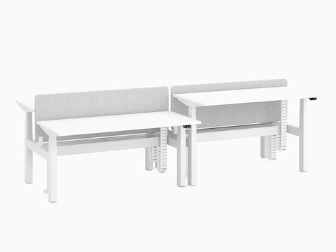 Nevi Link Sit-Stand back-to-back four-desk configuration in white with gray fabric screens and two desks raised to standing height.