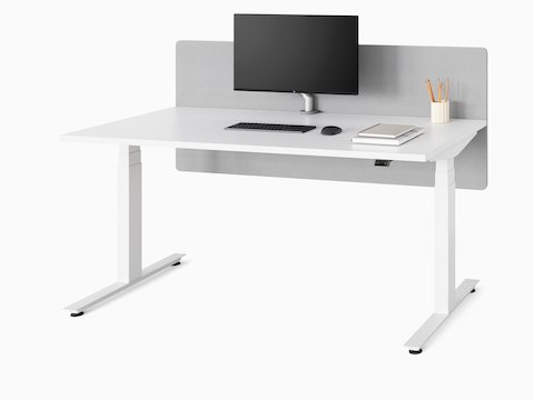 A white Nevi Sit-Stand Desk with a gray privacy screen, in the seated height position.