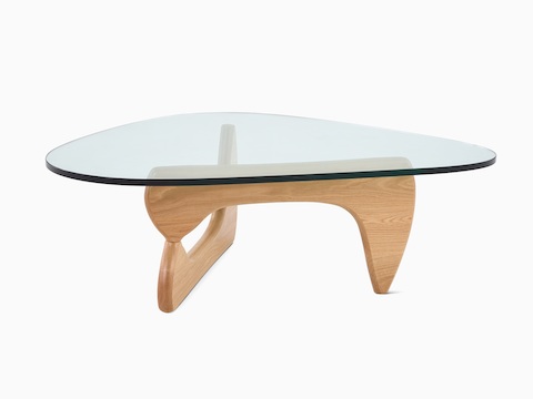 A Noguchi occasional table with a freeform glass top and curved wood base.