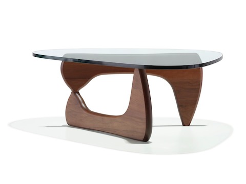 A Noguchi occasional table with a freeform glass top and curved wood base in a medium finish. 