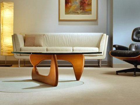 A Noguchi occasional table complements an ivory-colored Goetz Sofa and black Eames Lounge Chair. 