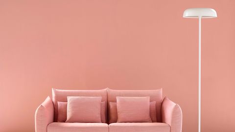 A white Ode floor lamp next to a salmon-colored Wireframe Sofa.