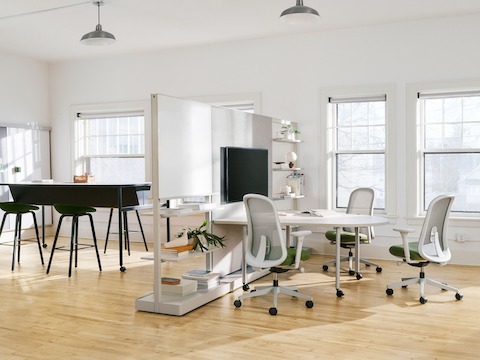 Grey OE1 Agile Walls and OE1 Huddle Table with grey and green Lino Chairs in the foreground, with black OE1 Communal Table in the background.