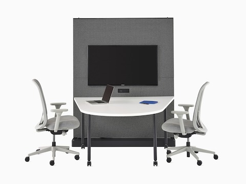 A black and grey OE1 Agile Wall with tackable fabric tiles and display unit, with a white OE1 Huddle Table and two grey Lino Chairs.
