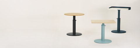 Three OE1 Sit-to-Stand Tables in various colors and surface shapes.