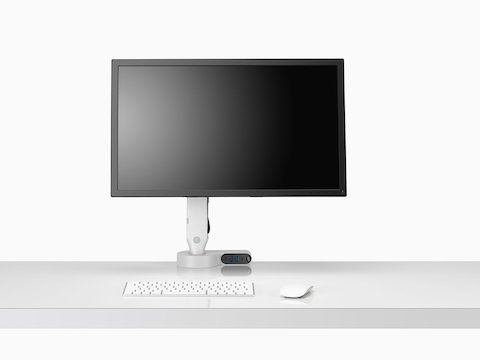 Front view of a screen attached to an Ollin Monitor Arm integrated with an Ondo Connectivity Module on a desk.
