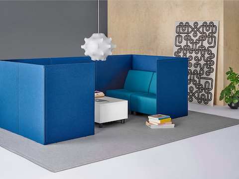 Blue fabric Pari freestanding privacy screens in a partially enclosed setting, with blue Swoop chairs and a white Swoop ottoman.