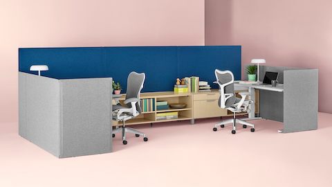 Gray fabric Pari freestanding privacy screens surrounding two Renew Sit-to-Stand Tables that's connected to Canvas Dock.
