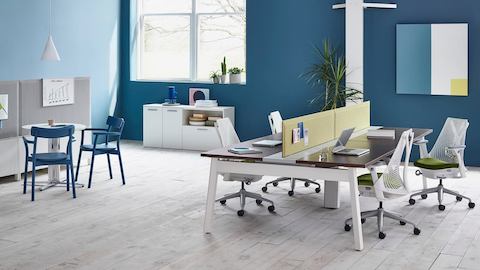 Un entorno de trabajo abierto anclado por Canvas Beam estaciones de trabajo con Pari pantallas de privacidad y blanco Sayl Chairs.