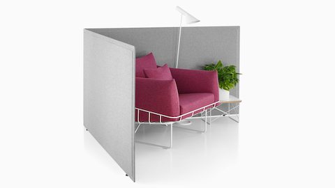 Las pantallas independientes Pari de color gris claro brindan el límite para una sala de estar con un sofá Wireframe en un tono rojo suave.