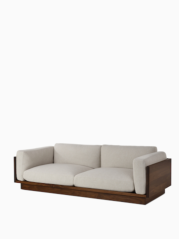 An angle view of the Pawson Drift Sofa in walnut frame and grey cushions