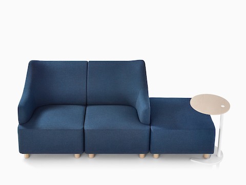 Overhead view of a Plex setting that includes a blue loveseat adjacent to a blue ottoman and work table. 