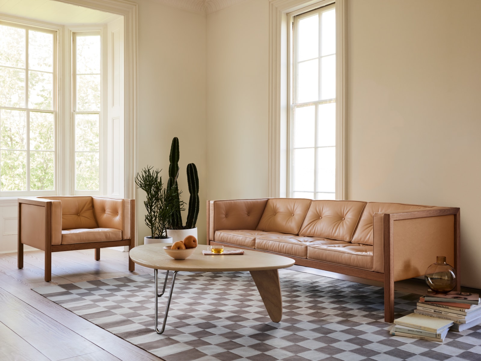 A Noguchi Rudder Table, Girard Check Rug, 80-inch Cube Sofa, and Cube Armchair in a living room setting.