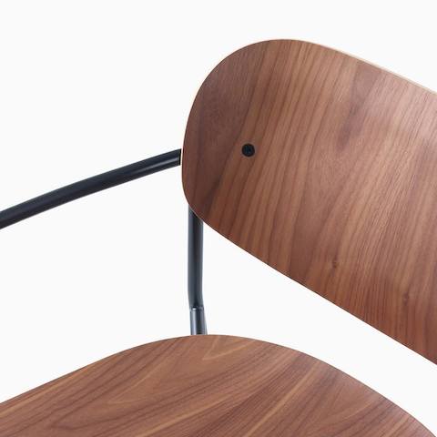 Detail image of Portrait Chair with Walnut seat and back, and black frame with arms.