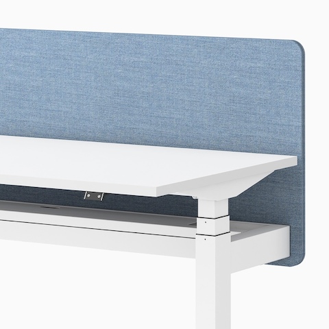 Close up view of a Ratio height adjustable desk in white with a frameless blue privacy screen.
