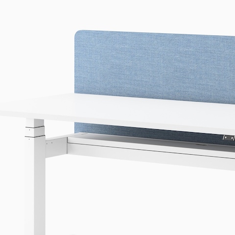 Close up view of a Ratio height adjustable desk in white with a frameless blue privacy screen.