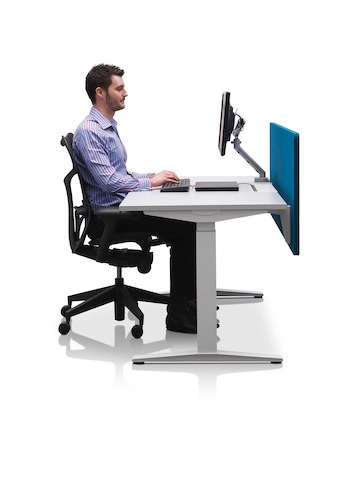 Mesa com ajuste de altura Ratio posicionadas nas altura para sentado com uma tela de privacidade azuis.